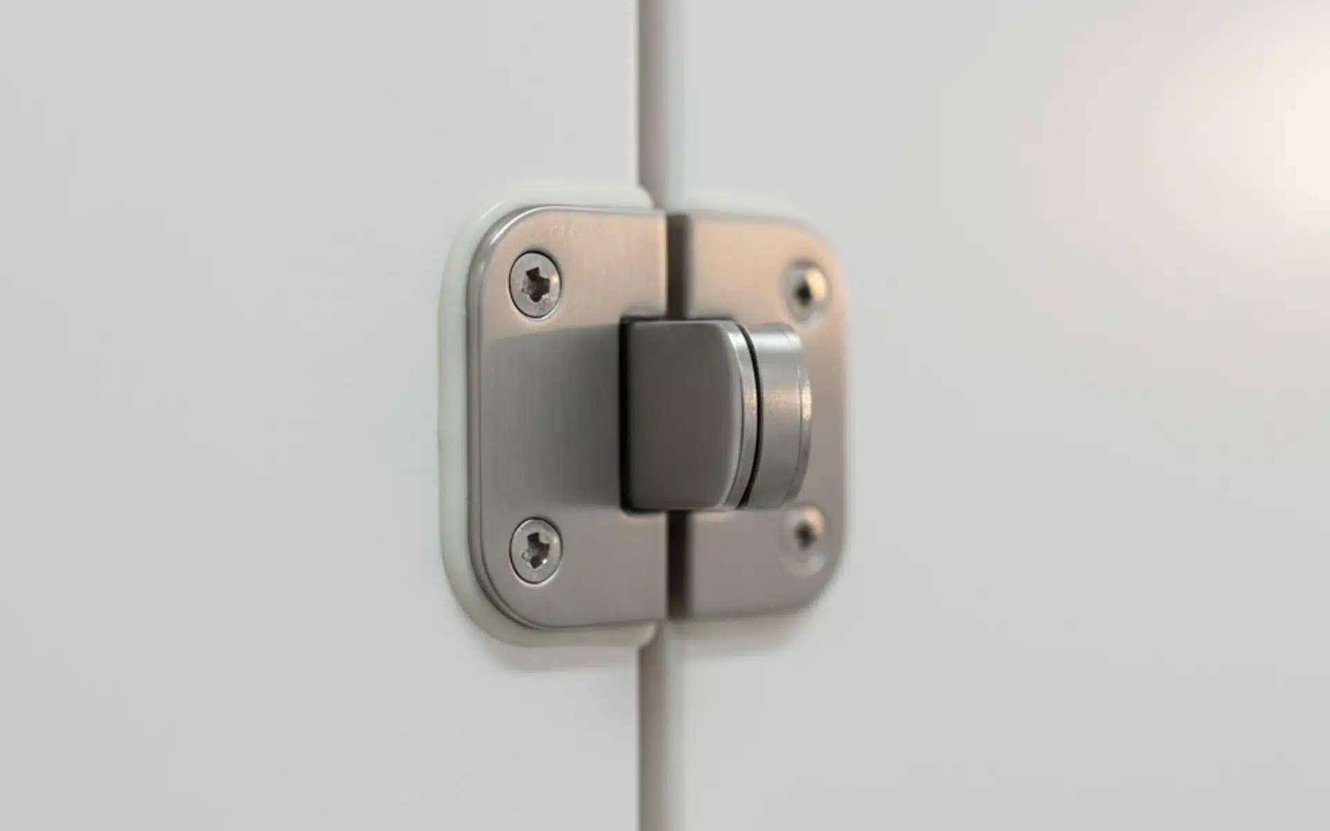 A close-up of a rusty, corroding metal door hinge with peeling paint, highlighting the need for durable hardware replacement.